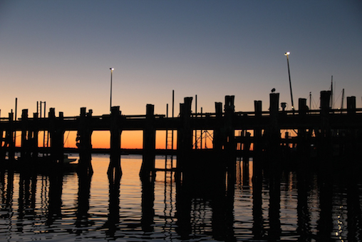 Sunset behind old Fisherman's Wharf pilings, now Provincetown Marina with modern facilities to accommodate small and big boats.